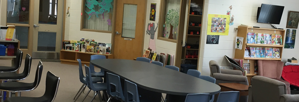 Tables, chairs, books in the Learning Commons area